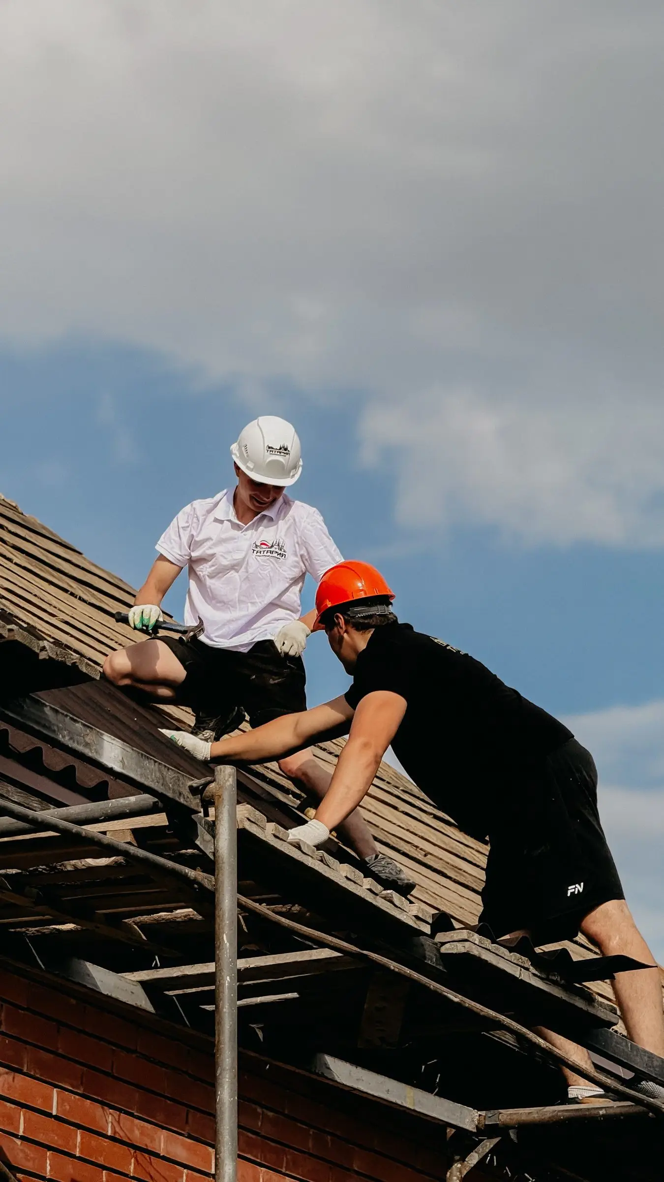 Two roofers working on a pitched roof
