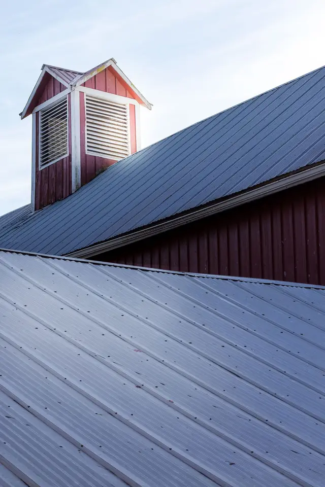 Grey standing seam metal roof with a cupola