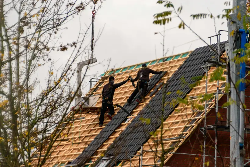 Roofers working across a stripped roof